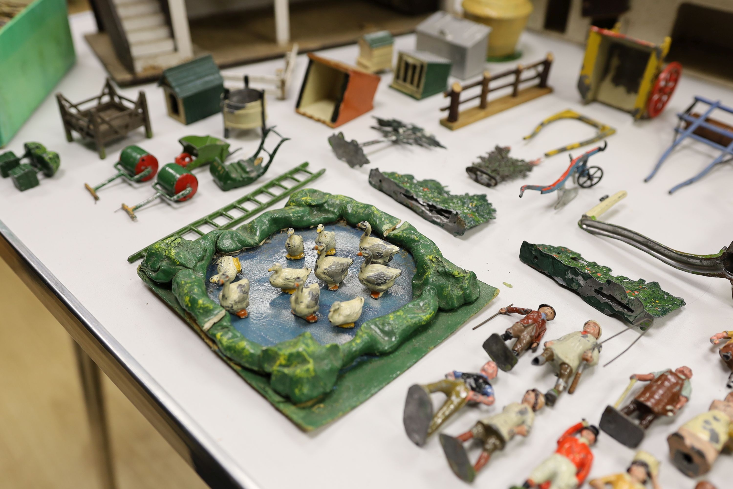 A collection of mainly Britains painted lead figures and animals, including huntsmen and hounds, farm workers, animals and wooden buildings